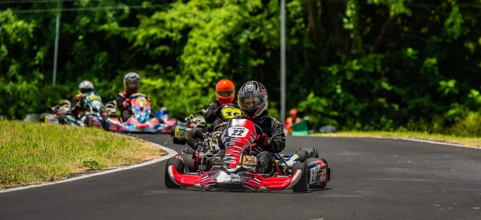 Pack de karts liderado por el #22 en una curva del Campeonato 4T